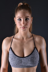 Fototapeta na wymiar Beautiful young sporty sexy woman showing muscle 