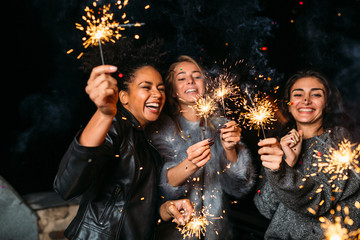 Young friends enjoying with sparklers at night