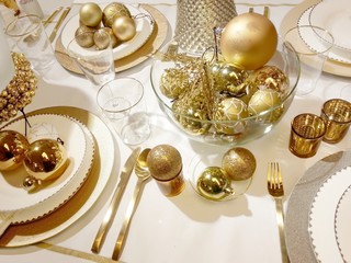 Beautiful table setting with Christmas decoration in golden color