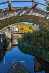 Fototapeta na wymiar Autumn Landscape with Roman Bridge in town of Shiroka Laka, Smolyan Region, Bulgaria