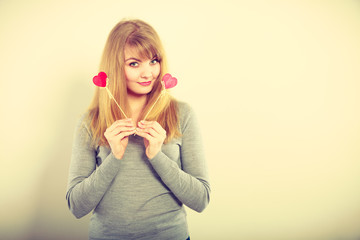 Lovely girl playing with hearts on sticks.