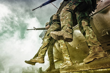 Soldiers boarding a military helicopter was landing in the jungle, Soldiers running through a...