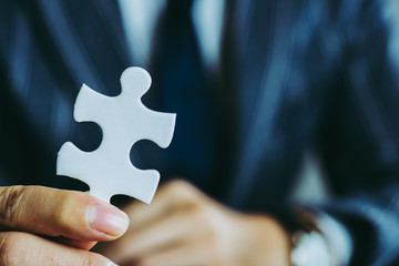 パズルのピースを持っているビジネスマン