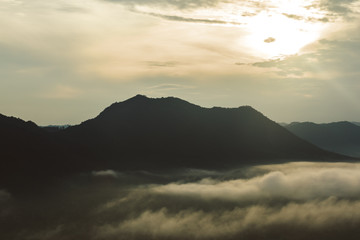 Mountain  in morning sun ray and winter fog