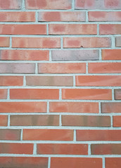 Mauer mit roten Ziegelsteinen und grauen Fugen als Hintergrund