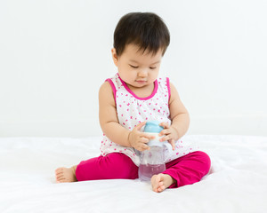 Portrait of adorable ibaby girl with a bottle of water, indoors