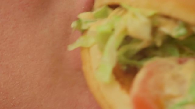 Closeup of a woman eating a big apetit burger