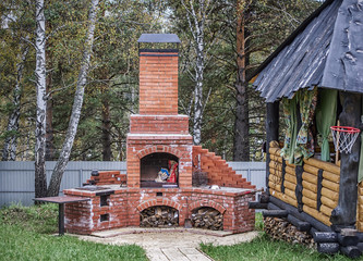 wooden gazebo and outdoor brick oven in backyard