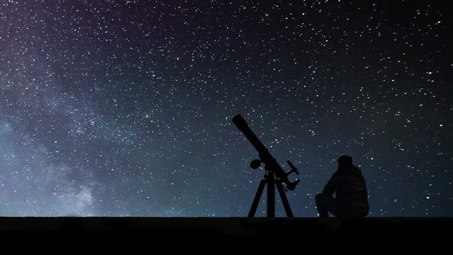 Man with astronomy telescope looking at the stars. Man telescope and starry sky. Night sky. Milky way galaxy Time Lapse.
