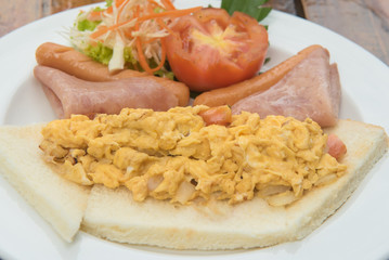 Table with nicely served American breakfast - sausages, vegetables, omelette. Egg dishes. Selective focus.