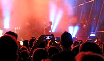 many people with modern smartphones during the live concert of a