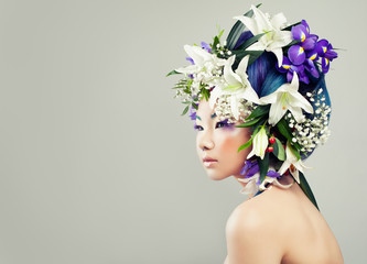 Beautiful Asian Model Woman with Colorful Flowers and Fashion Makeup. Spring Fashion Girl with White Lily and Iris Flowers