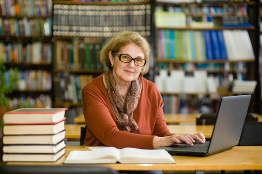 Senior woman reading book in library