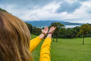 Fototapeta na wymiar Girl holding praying hands in green nature.