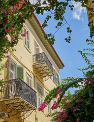 Greece, vintage house and flowers under blue sky