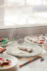 Woman making Christmas cookies in kitchen, Gingerbread cookies and candy in Christmas setting, selective focus