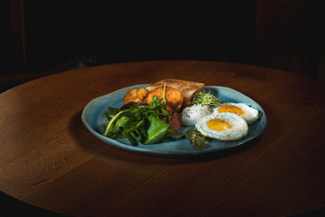Scrambled eggs on meat with fried potatoes and toast