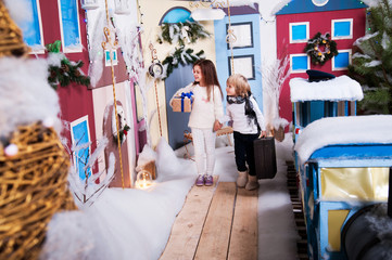 A little girl and a boy are walking around the New Year's city