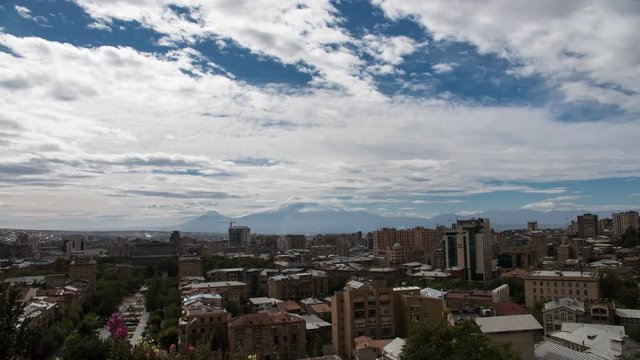 4K Timelapse of clouds above the city with huge mountain behind