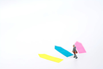 Three direction arrow choices, left, right or move forward, miniature model figure of businessman are taking decisions for the future, choice way.
