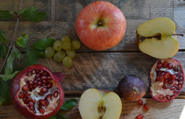 Autumn harvest concept - fruits on wooden table. Selective focus. Space for text. apple pomegranate grapes figs