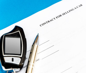 Contract for selling car with pen and car remote control. Business concept.