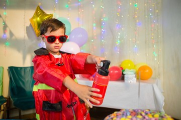 Cute boy pretending to be a fireman during birthday party