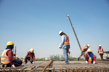 workers hands using steel wire and pincers to secure rebar before concrete is pour over it Construction site worker