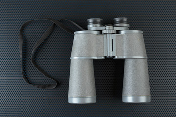 Binoculars on a metallic background