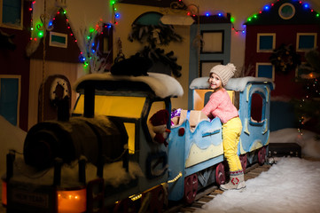 Little girl is playing with gifts on a New Year train.