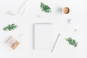 Christmas composition. Cup of coffee, notebook, thuja branches on white background. Christmas, winter, new year concept. Flat lay, top view, copy space