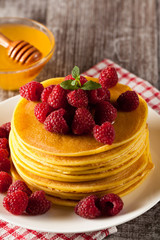 Fresh made delicious pancakes with berries, blackberries, raspberries, banana, honey and maple syrup. Healthy morning breakfast concept.