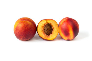 Row of three ripe peaches on the white background