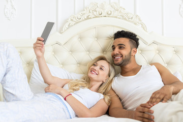 Young Couple Lying Bed Take Selfie Photo, Happy Smile Hispanic Man And Woman Lovers In Bedroom