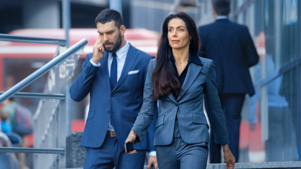 Male and Female Business People Walking Down the Street in the Business District.