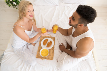 Obraz na płótnie Canvas Young Couple Breakfast Sitting In Bed, Happy Smile Young Hispanic Man And Woman Morning Top Angle View Lovers Bedroom
