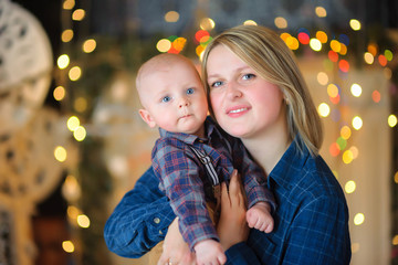 happy mother with a small son on the background of festive lights.