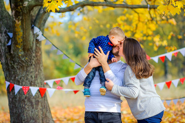 Obraz premium happy family walking in beautiful autumn park, hugging and having fun.