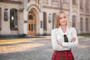 Young female student near university building