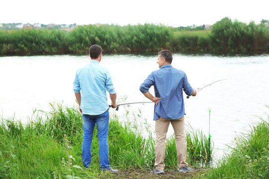 Men fishing from shore on river