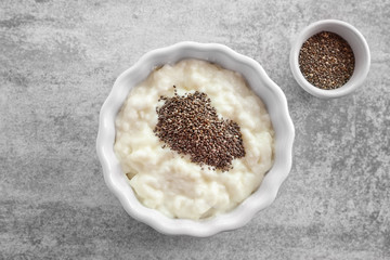 Pudding with chia seeds in bowl on grey background