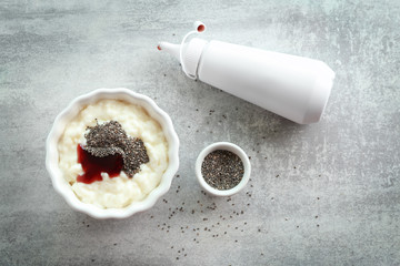 Composition with tasty pudding, chia seeds and jam on grey table