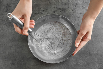 Woman making chia seed pudding on kitchen table