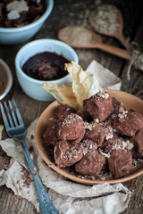 Coffee truffle, soft chocolate and cocoa on an old wooden table..