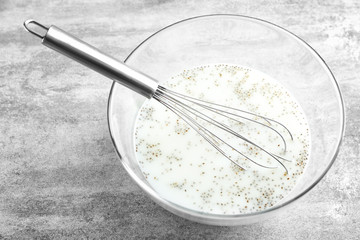 Glass bowl with yogurt and chia seeds on table