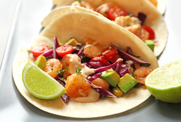 Plate with delicious shrimp tacos on kitchen table