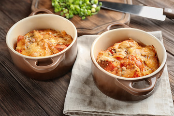 Cocottes with delicious sausage casserole on table