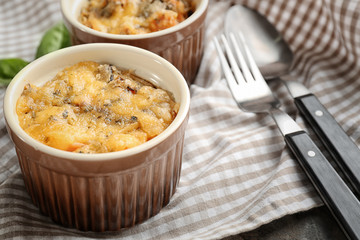 Ramekin with delicious sausage casserole on table, closeup