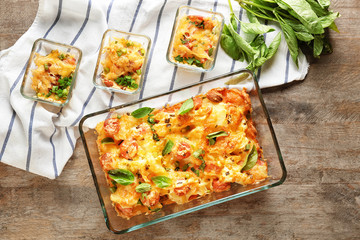 Baking dishes with delicious sausage casserole on table