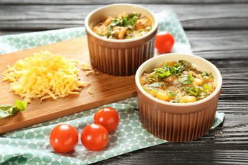 Ramekins with delicious sausage casserole on table